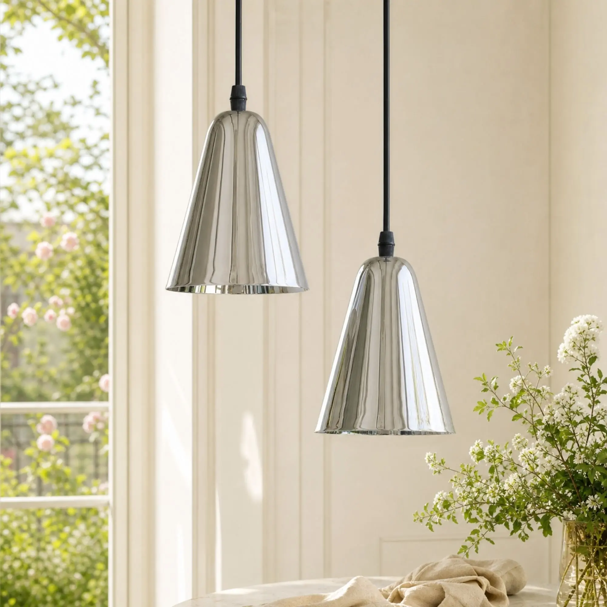 Pair of polished chrome pendant lights in a bright interior